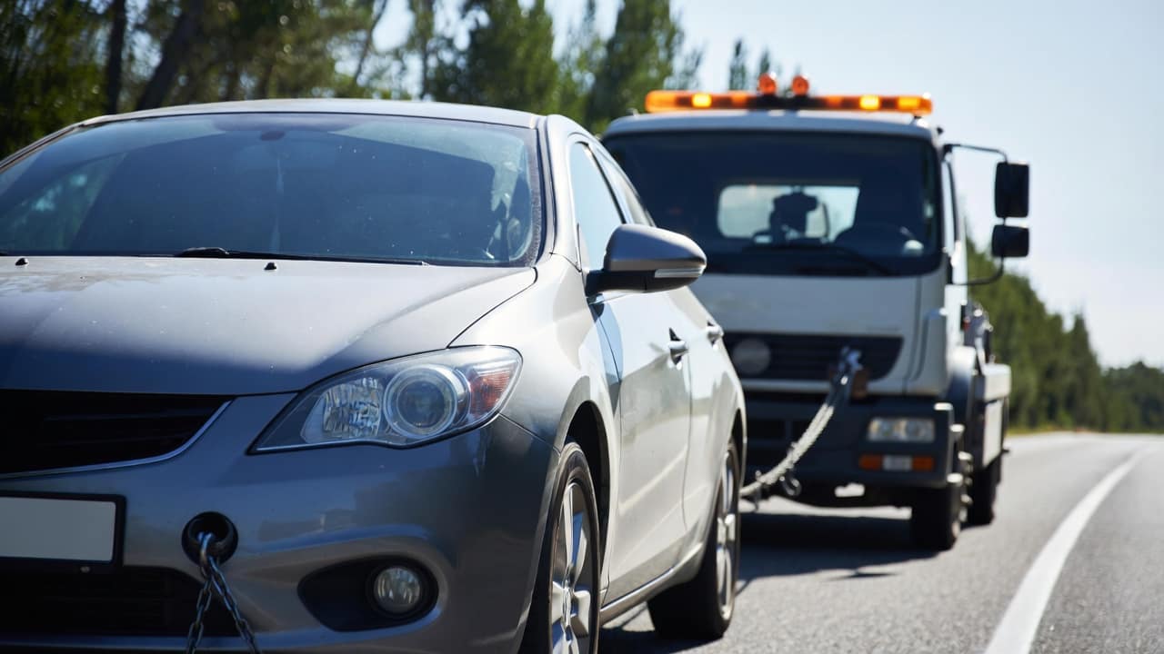 Technicien de dépannage remorquant une voiture en panne en Île‑de‑France pour assistance routière rapide