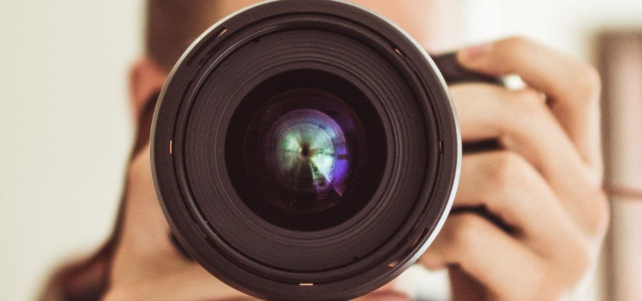 Comment maîtriser la profondeur de champ en photographie Photographe ajustant l’ouverture pour contrôler la profondeur de champ